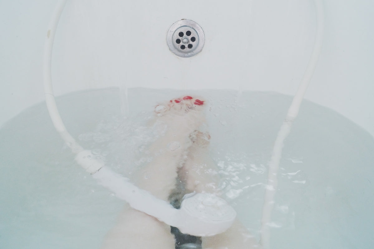 person sitting in white bathtub