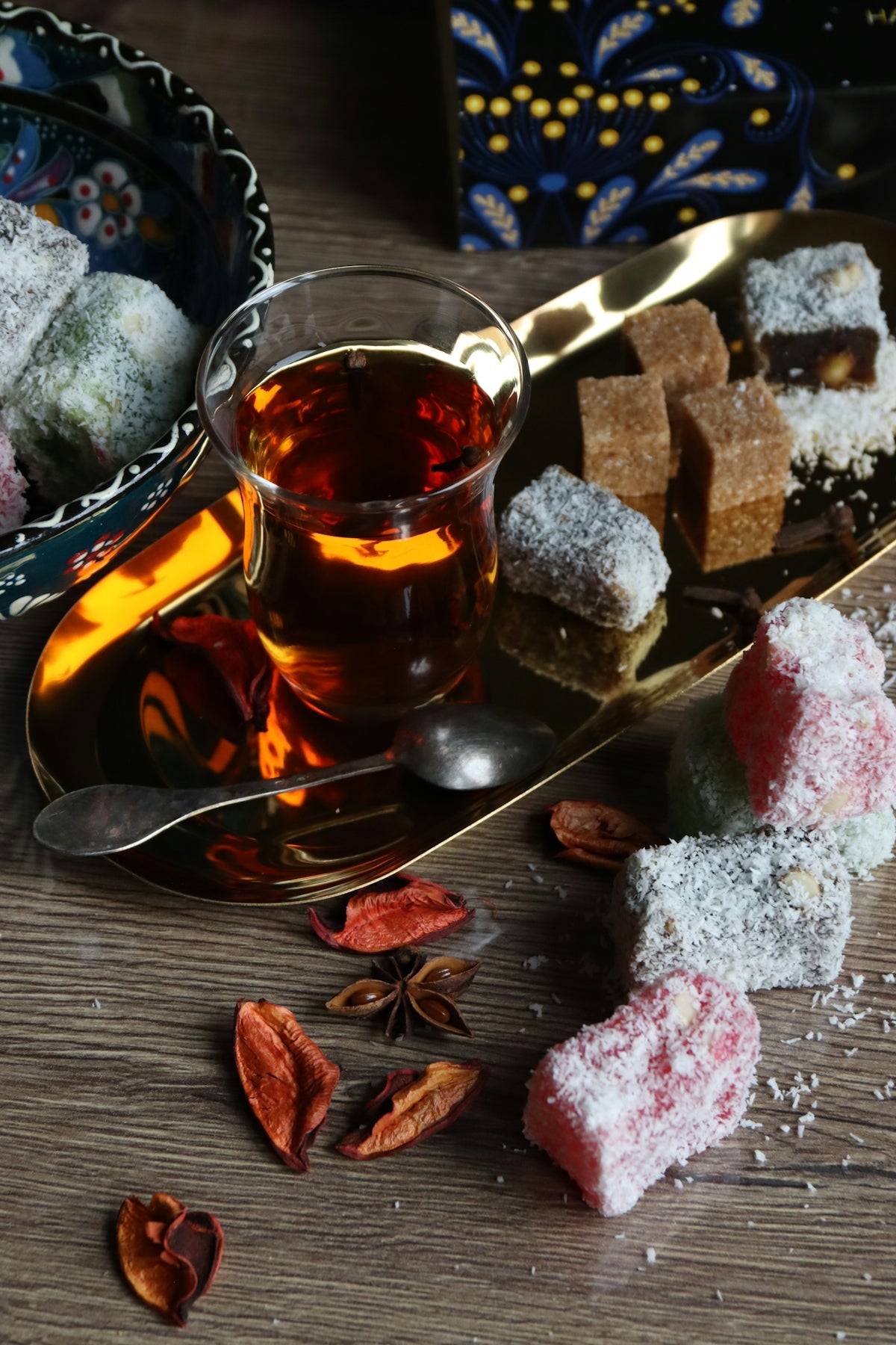 Tea, turkish delights, and spices on a wooden table.