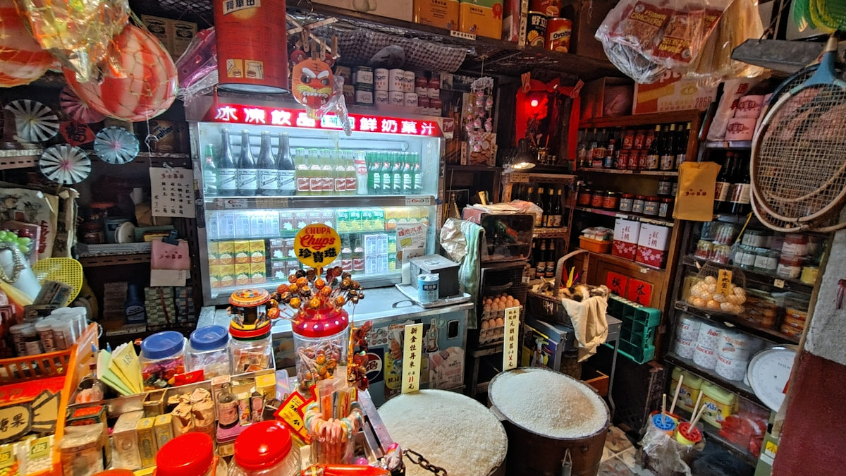 Cluttered convenience store interior with shelves full of goods.